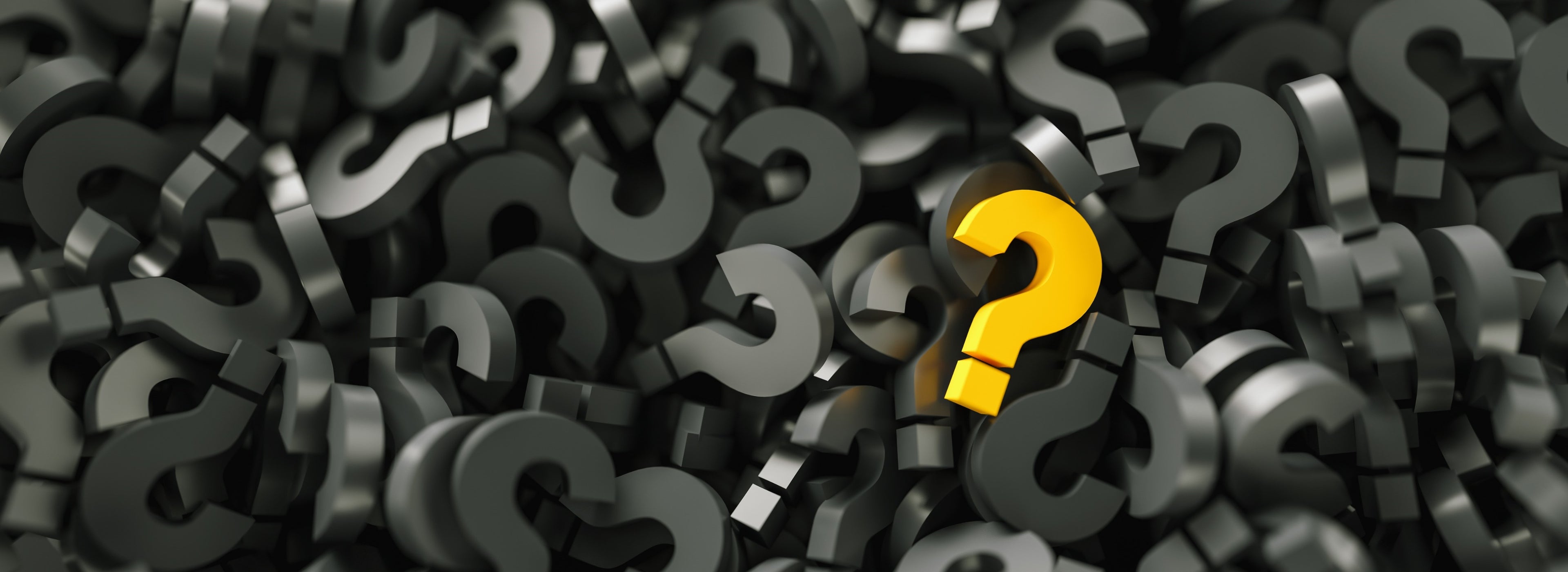 One yellow question mark floating on a sea of grey question marks.